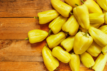 Mature whole pepper on wood background, top viewの写真素材