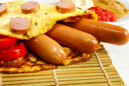 Breakfast of an omelette with sausages and coffee on a white wooden backgroundの写真素材