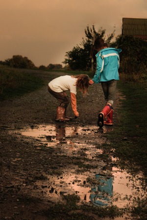 children after the rain with rubber bootsの写真素材