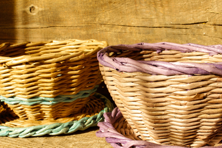 Empty basket with checked tablecloth on wooden table over grunge background. side view. close-upの写真素材