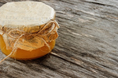 bank with honey on a gray wooden background. Side view, close-upの写真素材