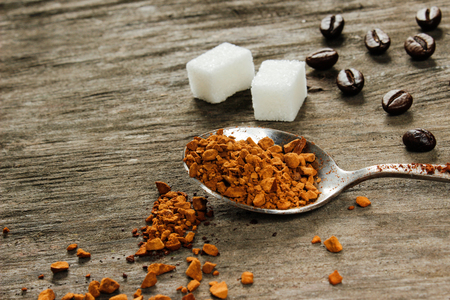 Coffee beans and instant coffee, white square sugar on a wooden table. Side viewの写真素材