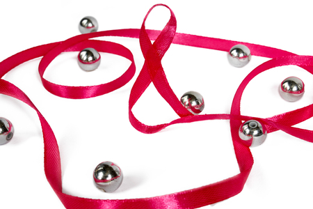 women's Day. greeting card from pink ribbon with the eighth of March and different beads on a white background. Insulation. Side view. Celebrationの写真素材
