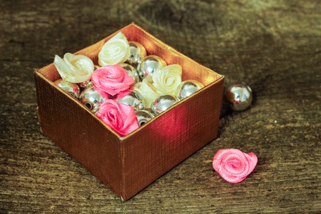 A box of beads and ribbons on a wooden surface. Close-up. Side viewの写真素材