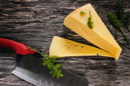 Hard cheese on a wooden table. Dairy products and agriculture. Close-up. Side viewの写真素材