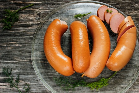 sausages with dill greens on a wooden surface. Close-upの写真素材