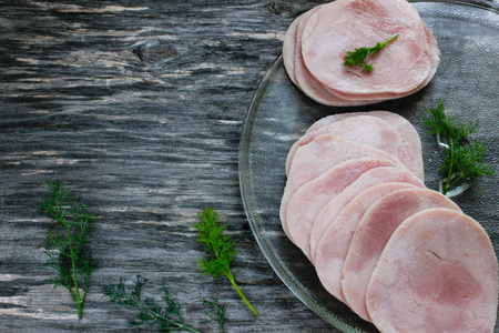 Sliced meat pieces, bacon, cold boiled pork, balyk on a wooden surface. Snack. Meat dish. Close-upの写真素材
