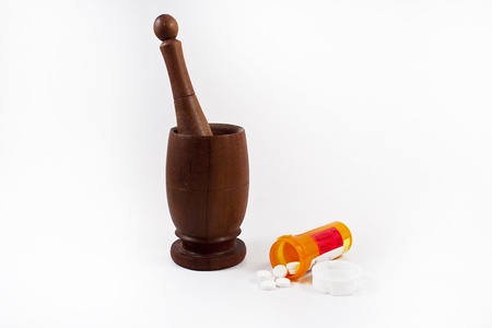 Mortar and pestle with pill bottle and pills on a white background.の写真素材