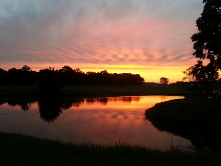 Glorious Colorful Sunset over Reflective Pond Waterの写真素材