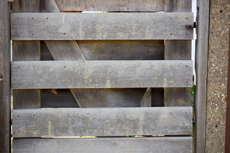 Old brown wood door with parts of wallの写真素材