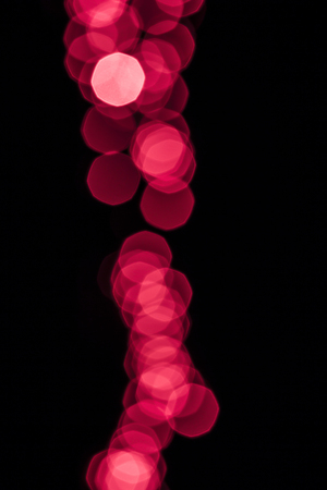 Dark overlay background of red LED lights with bokeh effect. Includes copy space.の写真素材