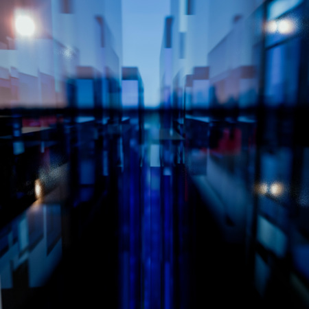 3D Illustration Abstract cityscape of three dimensional blue and red rectangular glass polygons against a blue sky with glow on the horizonの写真素材