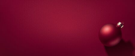 Christmas bauble on luxury red seamless backdrop, for modern design or winter holiday card...