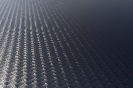Surface of a woven carbon fibre sheet viewed at an oblique low angle showing the texture and pattern in a full frame background view as light plays across from the sideの写真素材