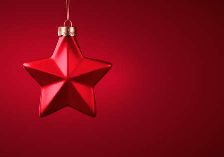 Red five-point star Christmas ornament. Shaped bauble hanging on golden thread against burgundy red...