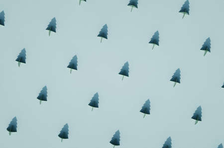Rows of green flat conifer tree contour Christmas ornaments on green surface. Christmas theme background.の写真素材