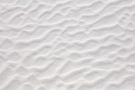 Abstract irregular pattern in white sand on beach. Textured summer background. Holiday at sea...