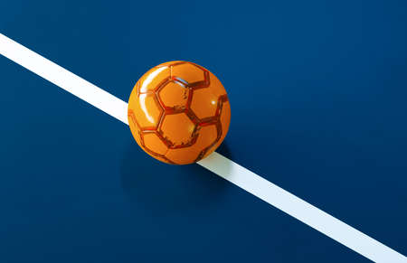 Orange futsal ball with light glow on the line of a blue indoor soccer fieldの写真素材