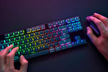 Personal point of view on player hands using color backlighted keyboard and mouse. Professional...