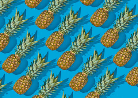 Pineapple fruits laying on light blue background. Mesh pattern with shadows. Tropical summer food background.の写真素材