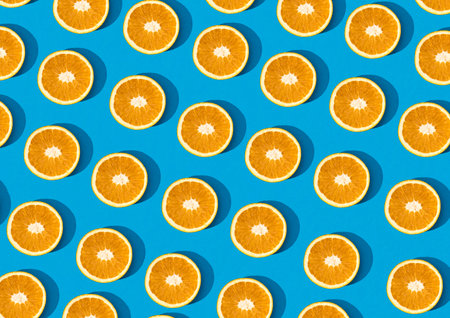 Top view orange fruit half cut pattern isolated on sky blue background. Fun creative fruit trendy...