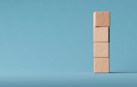 Four Wooden Cubes Are Stacked Vertically on a Soft Blue Surface, Creating a Simple and Modern...
