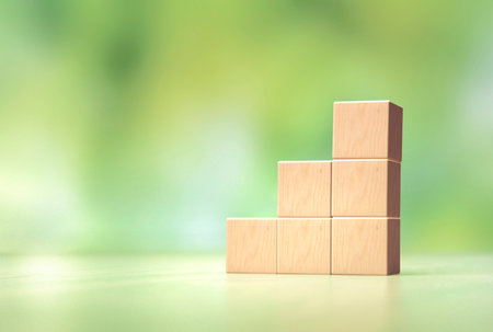 Wooden Cubes Are Neatly Stacked in a Stair-Step Formation Against a Softly Blurred Green Background....