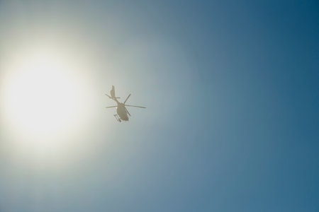 A Helicopter Soars High Above the North Sea Under Clear Blue Sky, Capturing the Essence of Aerial Exploration on a Sunny Day. This Scene Highlights the Connection Between Nature and Technology.の写真素材