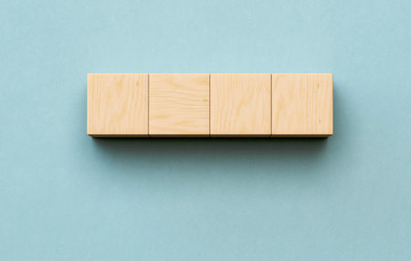Wood Cubes Are Neatly Placed in a Row on Soft Blue Background, Offering a Clean and Minimalistic Look Suitable for Creative or Educational Projects. The Simplicity Enhances Focus.の写真素材