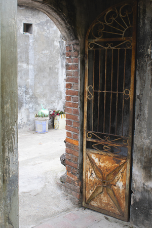 Rusty gate open in entry to traditional Vietnamese homeの写真素材