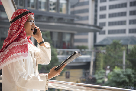 Smart handsome arab businessman using mobile phone in the city.の写真素材