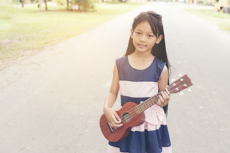 Cute little child girl playing guitar.の写真素材
