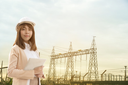 Smart Young beautiful Electrical engineer woman working using tablet for checking the power grids at electrical factory.の写真素材