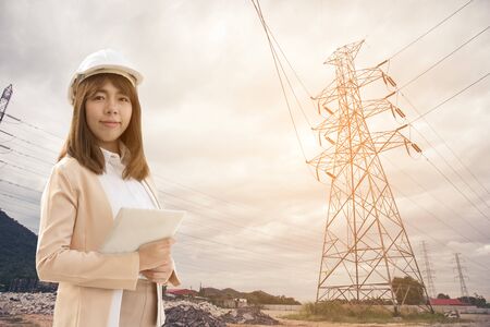 Smart Young beautiful Electrical engineer woman working using tablet for checking the power grids at electrical factory.の写真素材