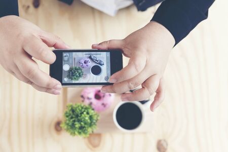 Chubby fat woman taking a photo of Donut and coffee cup from her smartphone at the seminar.の写真素材