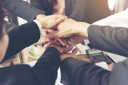 Businessman and engineer working  hands of business people joined hands together in office meeting. Teamwork Concept.の写真素材