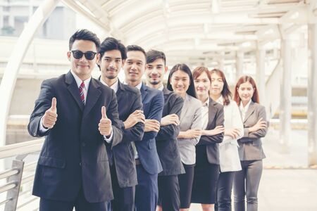 Business partners giving thumbs up after complete a deal to show potential of leadership with corporate partnership. Group of success business people working together. Team business concept.の写真素材