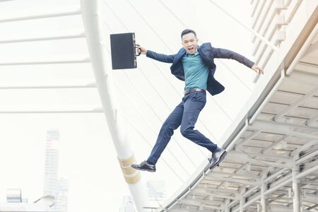 Success Business man jumping in the air. Happy businessman movement with cheerfulの写真素材