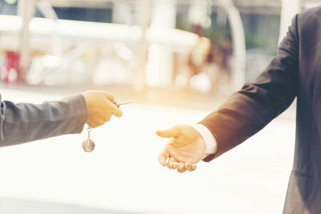 Car sale manager giving car key to customer. buy new car. mortgage concept.の写真素材