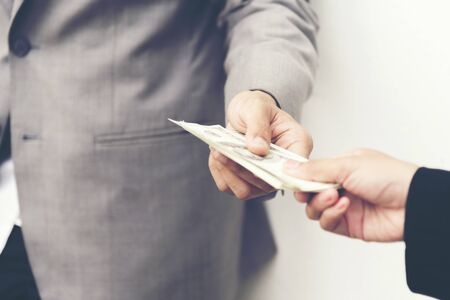 Businessman giving money to business woman. Corruption concept.