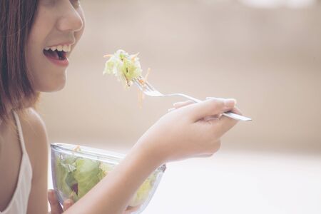 Healthy organic food. Young beautiful woman eating saladの写真素材