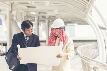 Success Arab Engineer wear white helmet hard hat for safety standing on city. Construction Conceptの写真素材