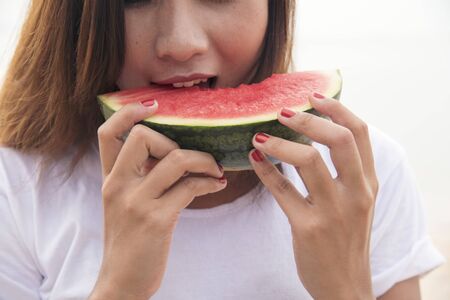 Young woman eating watermelon. Summer Concept.の写真素材