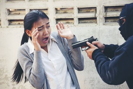 Robber thief criminal using gun extortion witness. Criminal concept.の写真素材