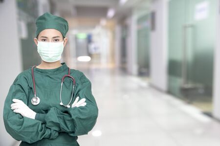 Asian women surgeon doctors with stethoscope wear mask at hospital clinic against corona covid-19 virus diagnostics analyse patient in hospital. Doctor clinical for theoretical laboratory studies caseの写真素材