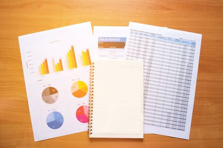 Empty Notebook. Reading report , graphs , charts, document at work. Business woman working at her desk.の写真素材