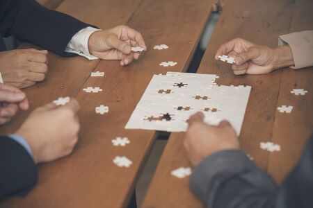 Implement improve puzzel solve connections together with synergy strategy team building organizing connection by trust communication. Hands of stakeholders business trust team holding jigsaw puzzleの写真素材