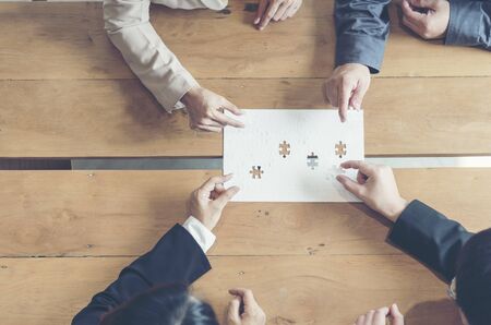 Implement improve puzzel solve connections together with synergy strategy team building organizing connection by trust communication. Hands of stakeholders business trust team holding jigsaw puzzleの写真素材