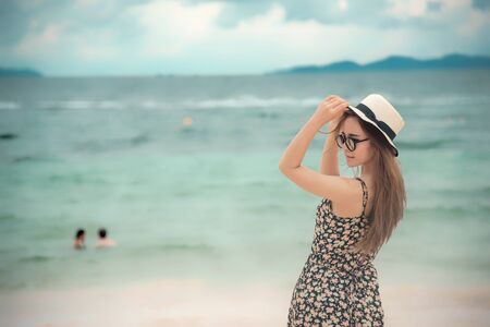 Woman barefoot walking on the summer beach. close up leg of young woman walking along wave of sea water and sand on the beach. Enjoyment barefoot walk outdoor with freedom. Relaxation Travel Concept.の写真素材