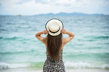 Woman bare foot walking on the summer beach. close up leg of young woman walking along wave of sea water and sand on the beach. Enjoyment barefoot walk outdoor with freedom. Relaxation Travel Concept.の写真素材